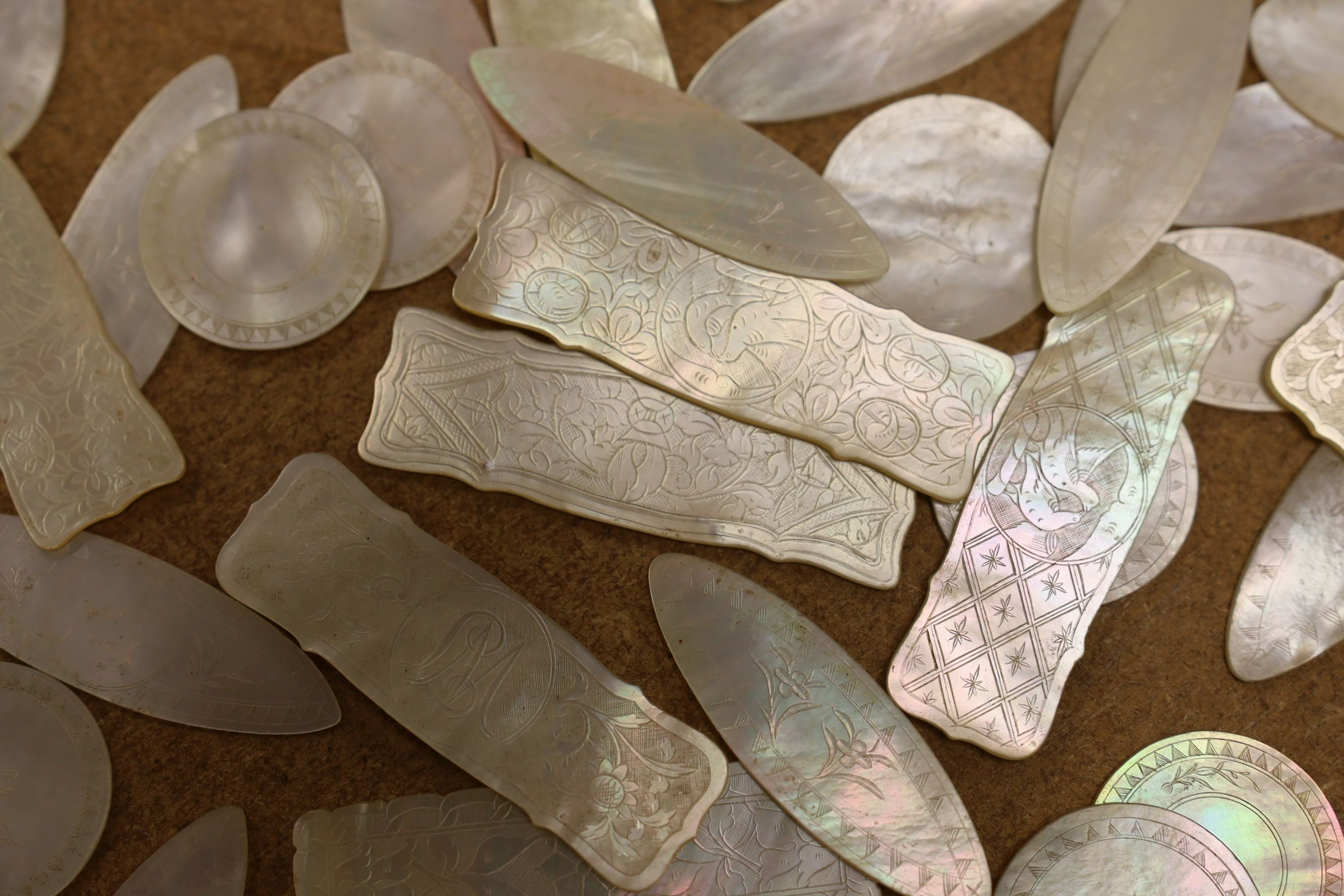 212 Chinese mother of pearl counters, 33 armorial and a wool winder